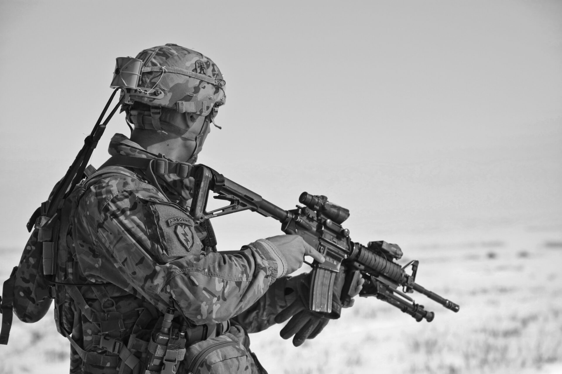 A soldier looking into its surrounding while holding his gun