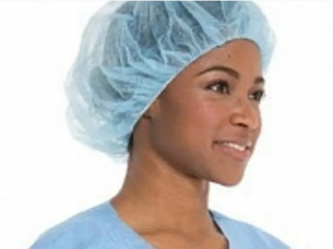A woman wearing a blue bouffant hair cover
